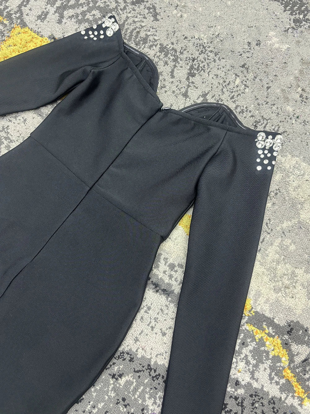 Black polyester bandage dress with long sleeves and crystal-embellished shoulders.