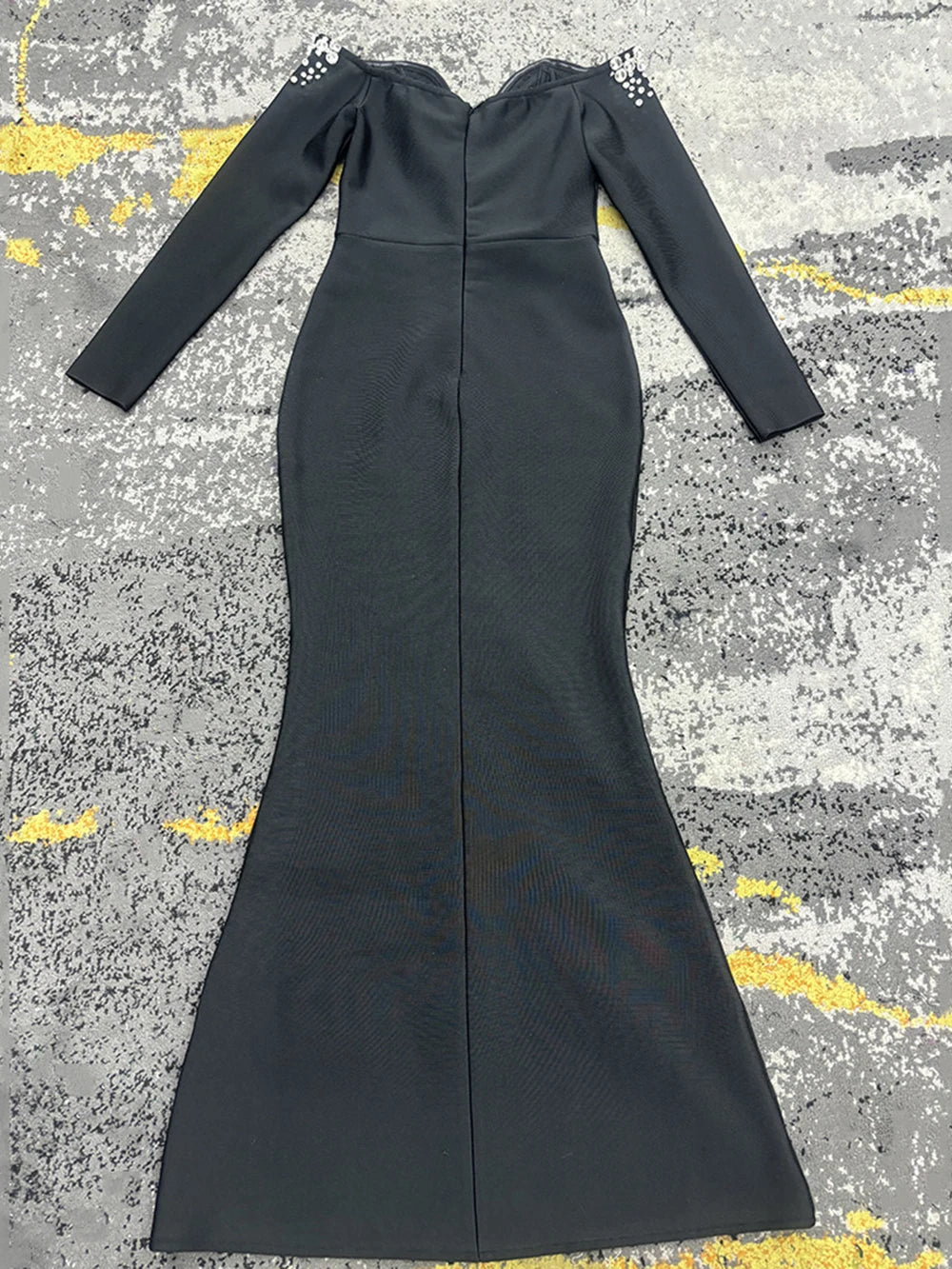 Black bandage dress in polyester, long sleeves with studded shoulder accents and a fitted mermaid silhouette.