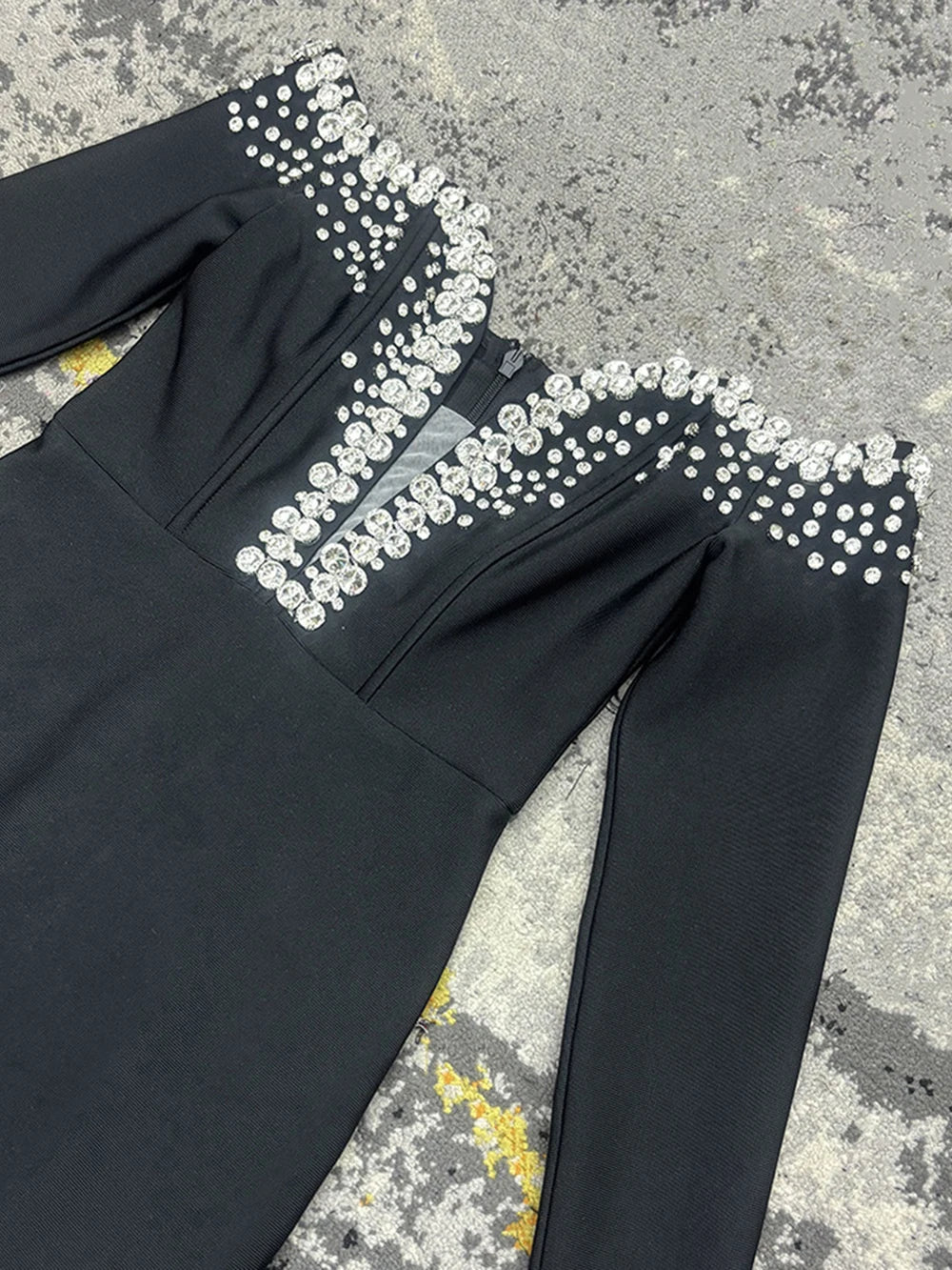 Bandage dress in black polyester with crystal embellishments along shoulders and neckline, long sleeves, back zipper